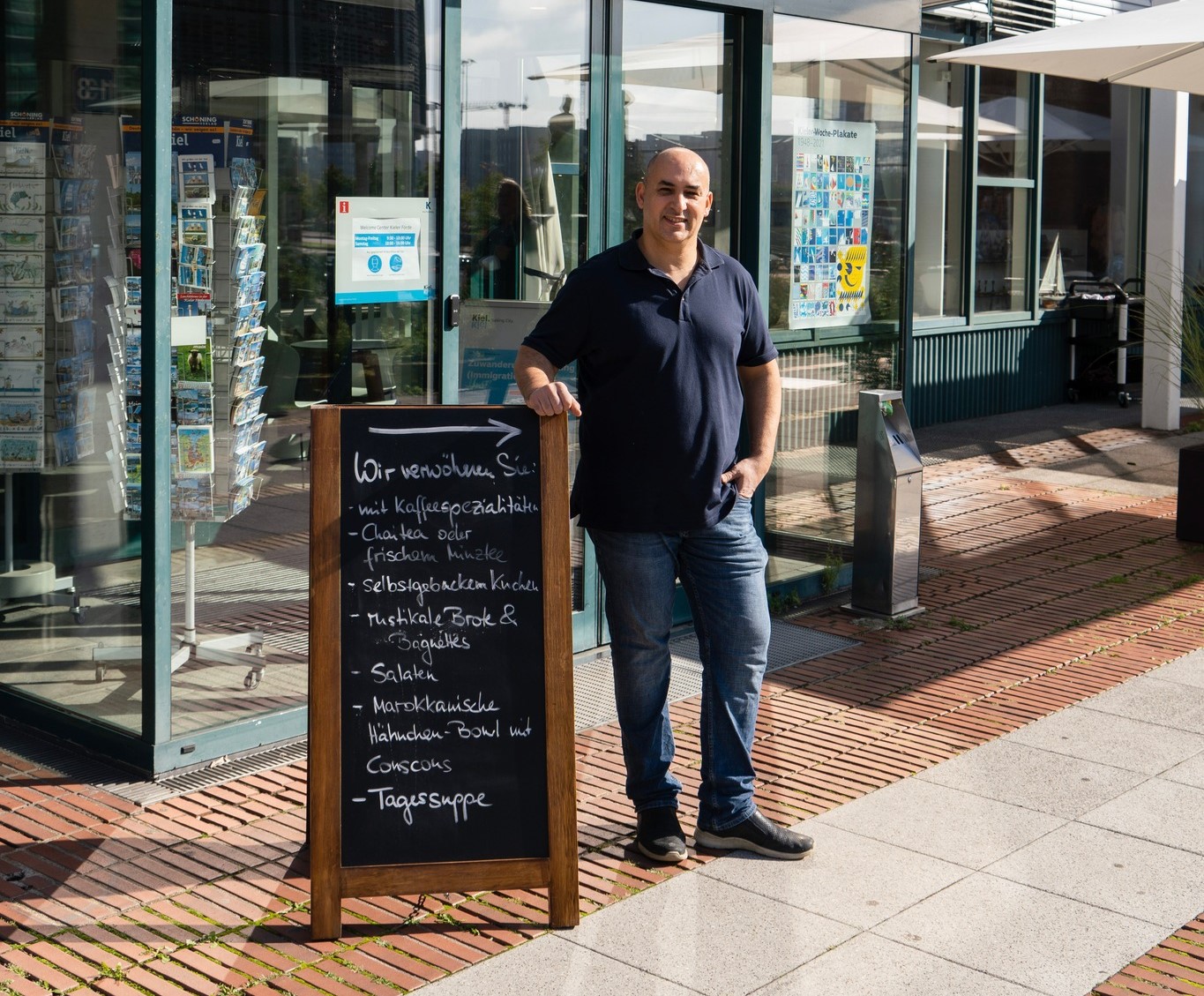 Der Betreiber vom Welcome Café Abdelilah Akaaboune steht vor dem Eingang Welcome Center Kiel.